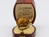 a small box with a ring inside of it on a white surface