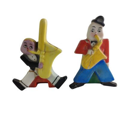 deux figurines représentant un homme jouant de la trompette et un homme jouant de la trompette
