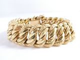 a close up of a gold bracelet on a white background