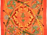 an orange silk scarf with an image of a sun and other symbols