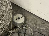 a wire ball and a can of soda sitting on the floor