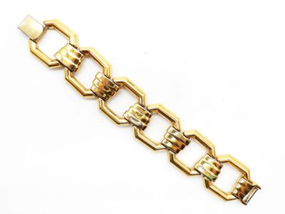 gros plan d'un bracelet en chaîne en or sur fond blanc