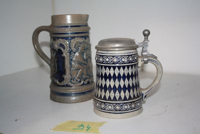 two beer mugs sitting next to each other on a table