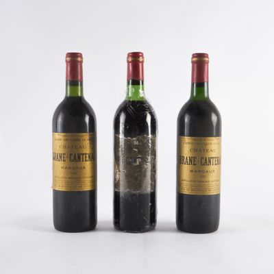 trois bouteilles de vin posées les unes à côté des autres sur une surface blanche