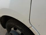 a white truck with a flat tire parked on the side of the road