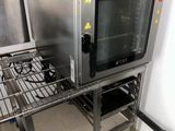un four argenté posé sur une grille métallique dans une cuisine