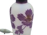 une photo d'un vase violet et blanc posé sur une table