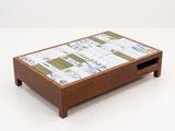 a wooden coffee table with a tile top and drawers