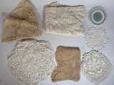 Plusieurs napperons au crochet sont disposés sur une surface blanche