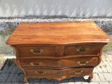 une commode en bois posée sur un sol en briques