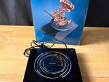 a black electric cooktop sitting on top of a wooden table