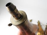 a person holding a small brass object in their hand