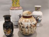 quatre vases posés sur une table, sur fond blanc