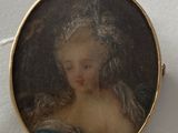 portrait of a woman in a blue dress in a gold broochle