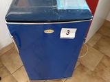 un petit réfrigérateur bleu sur lequel est posé un récipient en plastique