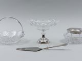 three pieces of glass and silverware including a spoon, a glass bowl, and a silver plate