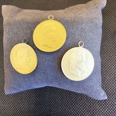 trois pièces d'or posées sur un oreiller, à côté d'un autre oreiller