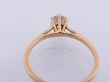 a close up of a gold engagement ring with a diamond