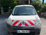 une camionnette blanche à rayures rouges et blanches garée devant une maison