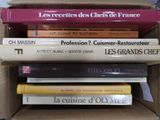 plusieurs livres sont empilés dans une boîte