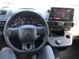 someone is sitting in the driver ' s seat of a car with their feet on the steering wheel