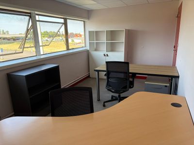 un bureau avec une chaise et un ordinateur dans un coin