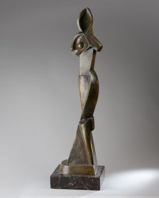 une statue en bronze d'une femme avec un chapeau sur la tête