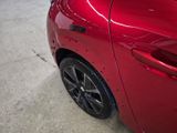 a close up of a red car parked in a garage