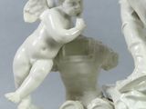 a statue of an angel and a cupid on a table