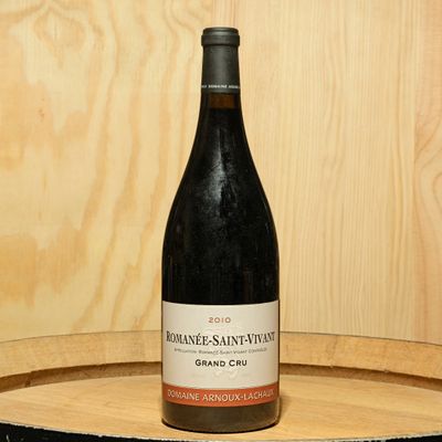 a bottle of wine sitting on top of a wooden barrel