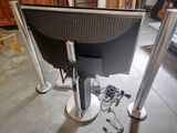 a computer monitor sitting on a stand in the middle of a room