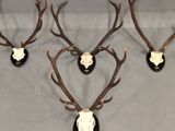 three deer heads mounted on a wall with antlers on them