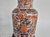 a vase that is sitting on a stand on a white surface
