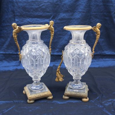 paire de vases anciens en verre taillé, munis de poignées en laiton et reposant sur des socles en marbre