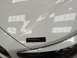 a close up of a white sports car in a showroom