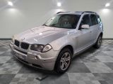 une photo d'un SUV BMW argenté posé sur un sol à damier