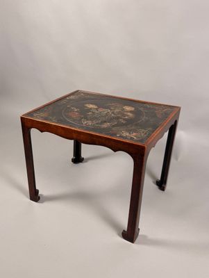 une image représentant une petite table en bois ornée d'un motif noir et or