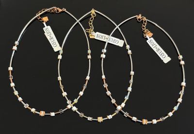 trois colliers en argent et en or, ornés de breloques et de pendentifs