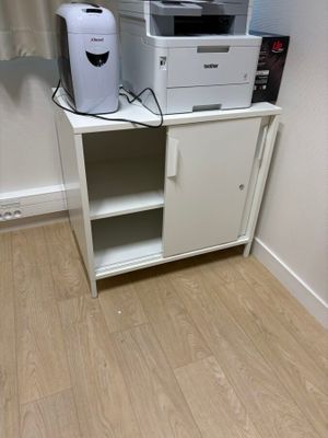 une armoire blanche sur laquelle sont posés une imprimante et un grille-pain