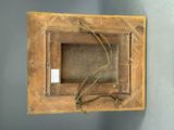 an old wooden frame with a rope hanging from it ' s side