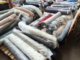 many rolls of fabric on a pallet in a warehouse