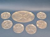 six carved glass medallions with flowers on them on a blue surface