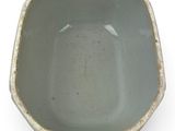 a gray bowl with a black handle on a white surface