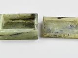 two pieces of green jade are sitting next to each other