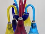 Des vases en verre aux couleurs vives sont disposés sur une table devant un miroir