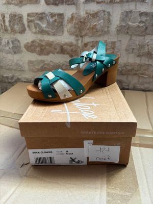 green and white sandals on a cardboard box on top of a cardboard box