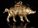 un gros plan d'un pendentif en forme de cochon doré sur fond noir