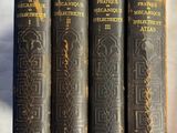 quatre vieux livres sont alignés sur une surface blanche