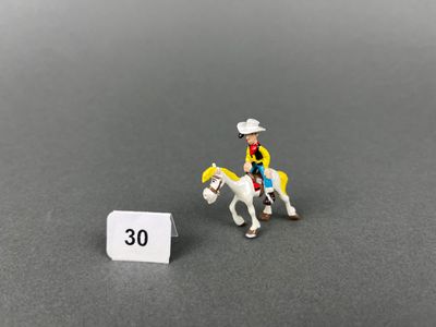 petite figurine représentant un homme à cheval à côté d'un panneau