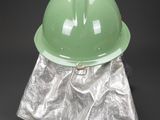 a green helmet sitting on top of a piece of silver foil